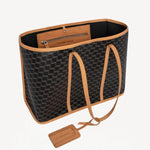 Open view of black/tan canvas cube and calf cab tote on white background, with no model shown.