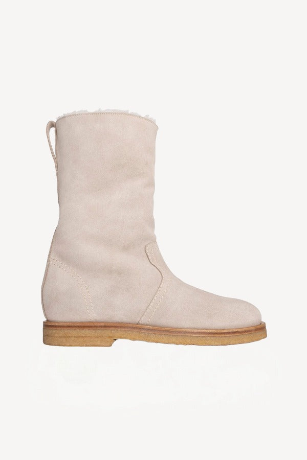 Right side view of off white montana suede and sherling ankle boot on white background, with no model shown.