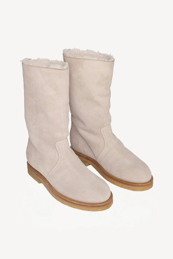 Front slanted view of off-white montana suede and sherling ankle boot on white background, with no model shown.