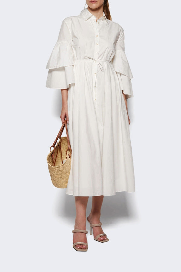 Front view of white fiesta shirt dress on model wearing beige heels, against a white background.