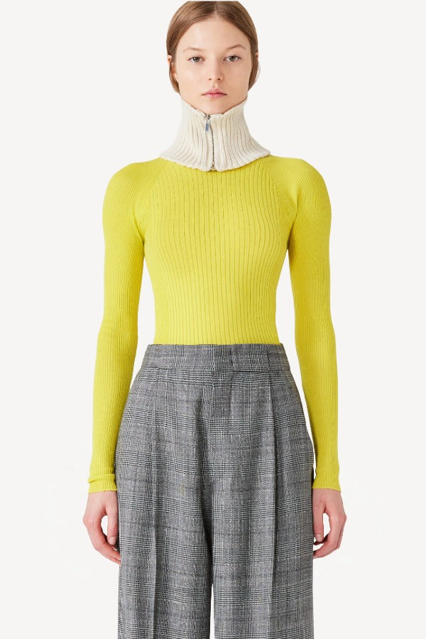 Front closeup view of grigio fantasia bogart wool/silk trousers on model wearing yellow sweater, against a white background.