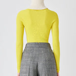 Back closeup view of grigio fantasia bogart wool/silk trousers on model wearing yellow sweater, against a white background.