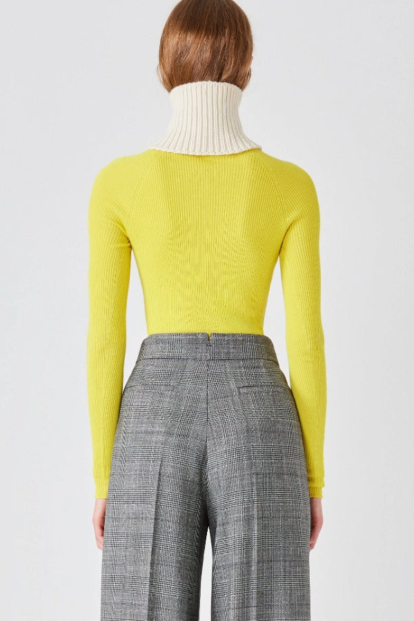 Back closeup view of grigio fantasia bogart wool/silk trousers on model wearing yellow sweater, against a white background.