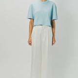 Front view of cielo cashmere cropped t-shirt on model wearing white pants, against a white background.
