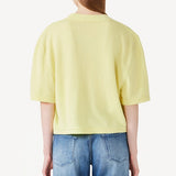 Back view of yellow cashmere cropped t-shirt on model wearing jeans, against a white background.