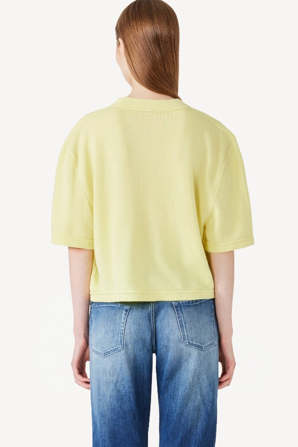 Back view of yellow cashmere cropped t-shirt on model wearing jeans, against a white background.