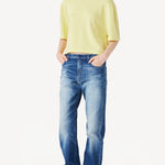 Front view of yellow cashmere cropped t-shirt on model wearing jeans and boots, against a white background.