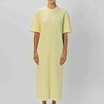 Front view of yellow cashmere long t-shirt dress on model wearing sandals, against a white background.