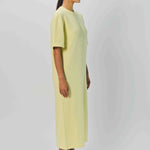 Alternate side view of yellow cashmere long t-shirt dress on model wearing sandals, against a white background.