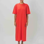 Front view of orange cashmere long t-shirt dress on model wearing sandals, against a white background.