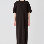 Front view of brown cashmere long t-shirt dress on model wearing boots, against a white background.