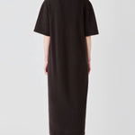 Back view of brown cashmere long t-shirt dress on model wearing boots, against a white background.