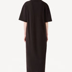 Back view of brown cashmere long t-shirt dress on model wearing black boots, against a white background.