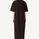 Back view of brown cashmere long t-shirt dress on model wearing black boots, against a white background.