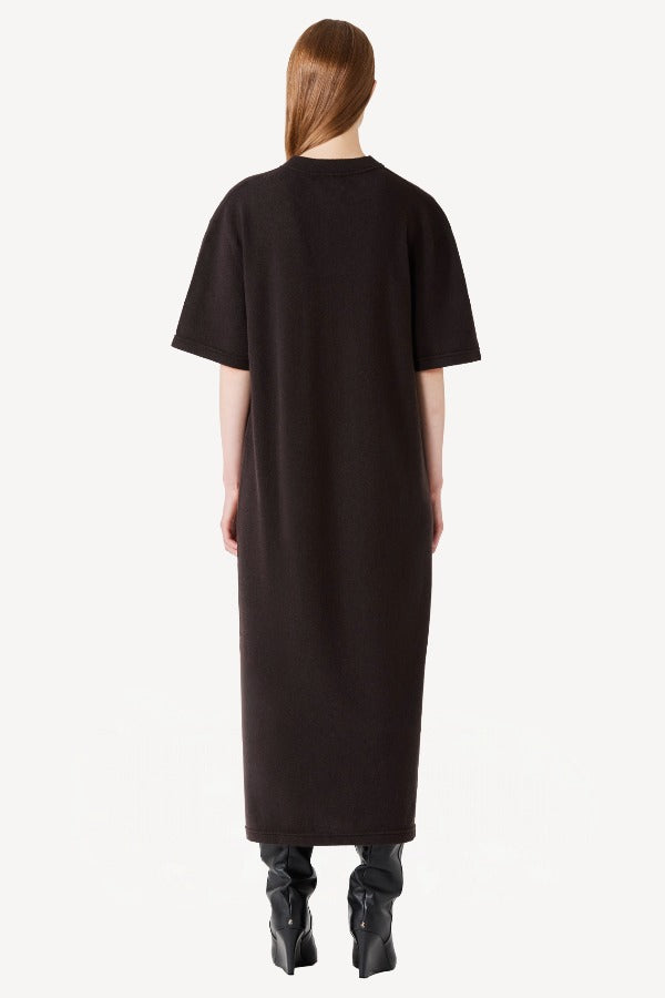 Back view of brown cashmere long t-shirt dress on model wearing black boots, against a white background.