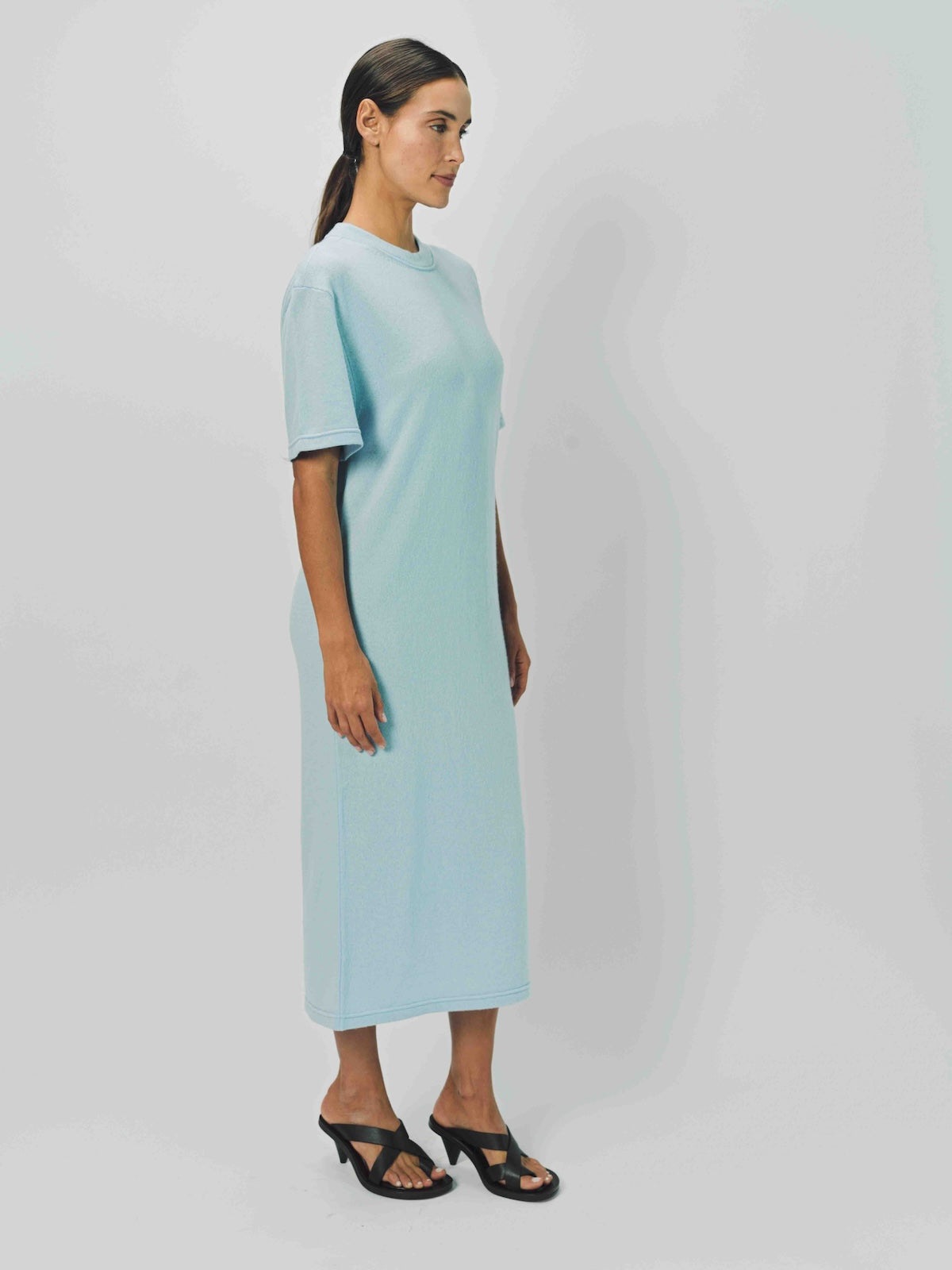 Alternate side view of cielo cashmere long t-shirt dress on model wearing sandals, against a white background.