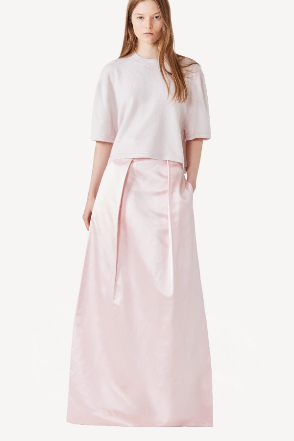 Front view of pink duchesse bogart long skirt on model wearing pink top, against a white background.