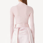 Back view of pink duchesse bogart long skirt on model wearing pink top, against a white background.