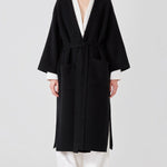 Front view of black isabella kimono coat on model wearing white top and pants, against a white background. 