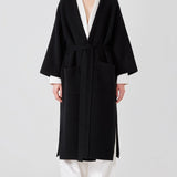 Front view of black isabella kimono coat on model wearing white top and pants, against a white background. 