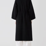 Back view of black isabella kimono coat on model wearing white top and pants, against a white background.
