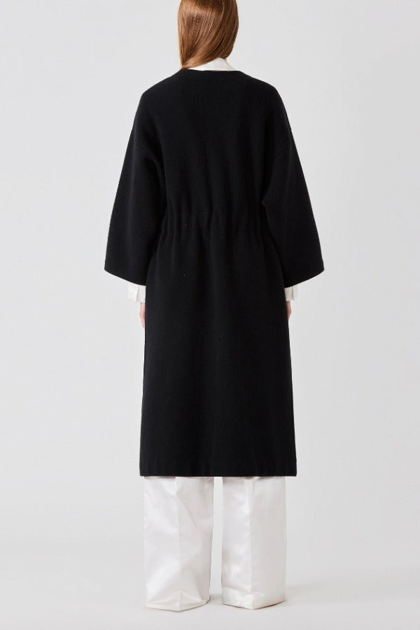 Back view of black isabella kimono coat on model wearing white top and pants, against a white background.