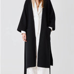 Open view of black isabella kimono coat on model wearing white top and pants, against a white bacgkround.