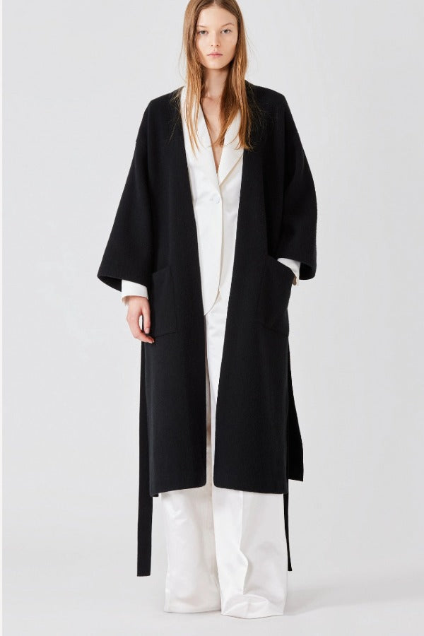 Open view of black isabella kimono coat on model wearing white top and pants, against a white bacgkround.