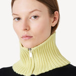 Front view of yellow knit cashmere collar scarf on model wearing black sweater, against a white background.