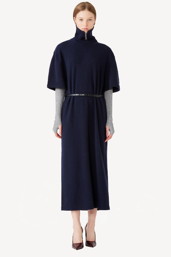 Front view of navy knit cashmere collar scarf on model wearing navy dress, against a white background.