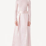 Front view of light pink l/s high neck sweater on model wearing a pink skirt, against a white background.