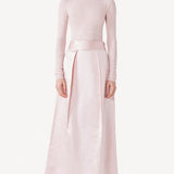 Front view of light pink l/s high neck sweater on model wearing a pink skirt, against a white background.