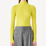 Front view of yellow l/s cashmere high neck sweater on model wearing grey pants, against a white background