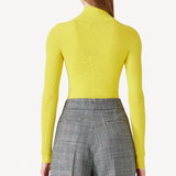 Back view of yellow l/s cashmere high neck sweater on model wearing grey pants, against a white background.