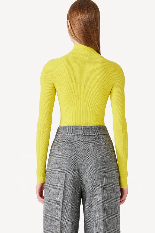 Back view of yellow l/s cashmere high neck sweater on model wearing grey pants, against a white background.