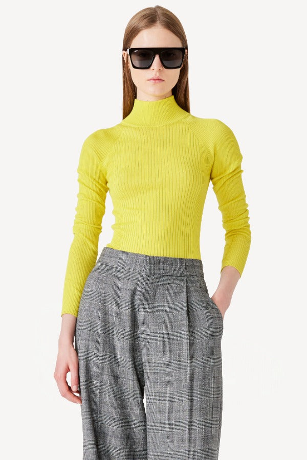 Alternate front view of yellow l/s cashmere high neck sweater on model wearing grey pants, against white background