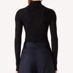 Back view of black l/s cashmere high neck sweater on model wearing navy pants, against a white background.