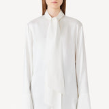 Front view of ivory L/S Double Satin Shirt with Scarf on model wearing black pants, against a white background.