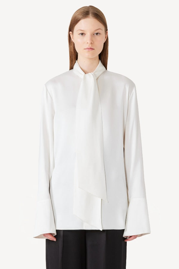 Front view of ivory L/S Double Satin Shirt with Scarf on model wearing black pants, against a white background.