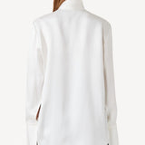 Back view of ivory l/s double satin shirt with scarf on model wearing black pants, against a white background.