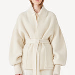 Front view of ivory gemma cardigan on model wearing white pants, against a white background.
