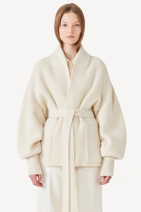 Front view of ivory gemma cardigan on model wearing white pants, against a white background.