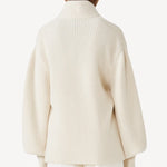 Back view of ivory gemma sweater on model wearing white pants, against a white background.