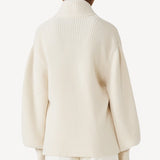 Back view of ivory gemma sweater on model wearing white pants, against a white background.