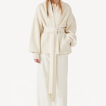 Front view of ivory gemma cardigan on model wearing white pants, against a white background.