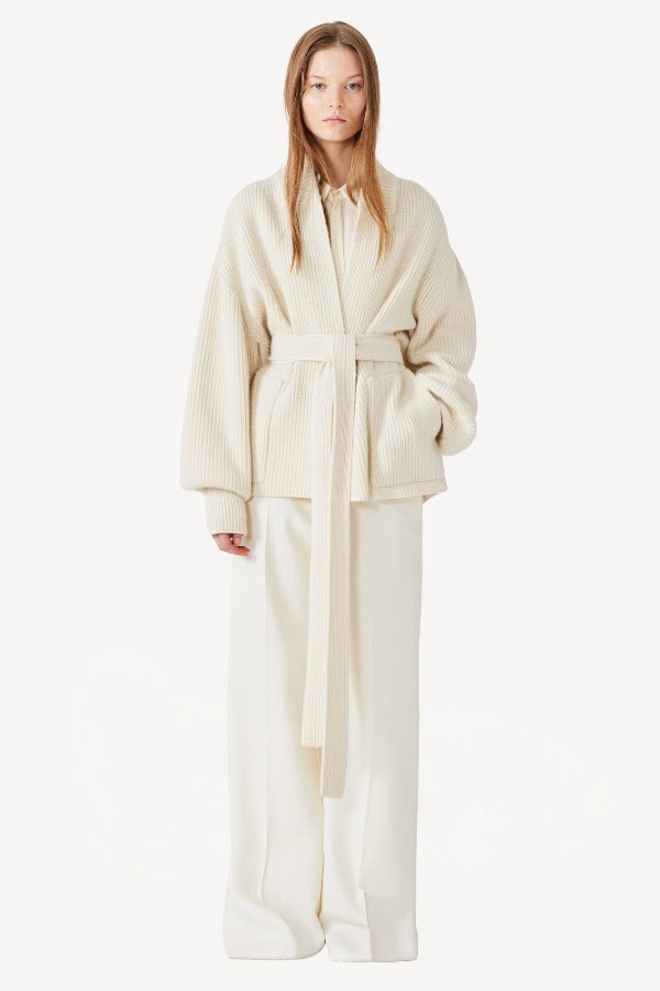 Front view of ivory gemma cardigan on model wearing white pants, against a white background.