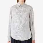 Front view of white/navy L/S Silk marcella shirt on model wearing navy pants, against a white background.