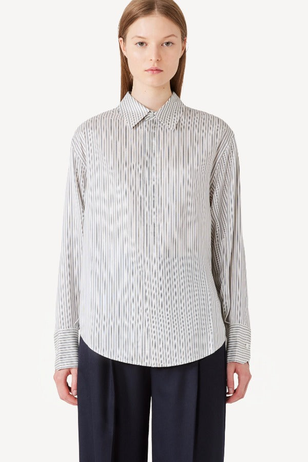 Front view of white/navy L/S Silk marcella shirt on model wearing navy pants, against a white background.
