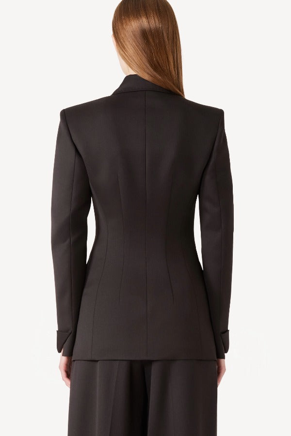 Back view of brown l/s wool double breast tuxedo jacket on model wearing brown pants, against a white background.