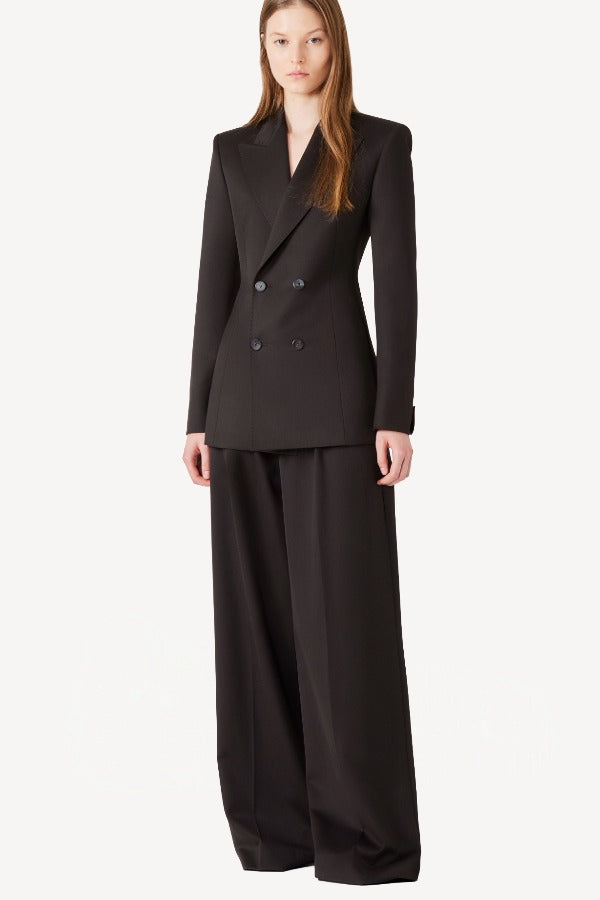 Front view of brown l/s wool double breast tuxedo jacket on model wearing brown pants, against a white background.